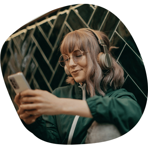 Femme écoutant sa chanson personnalisée sur son téléphone avec un casque audio.